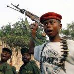 Млади войници от подкрепяна от Уганда конгоанска бунтовническа група пеят освободителни песни, размахвайки пушки на снимка от 30 януари 2002 г. в североизточния конгоански град Буня. Снимка: Karel Prinsloo, AP, NTB scanpix