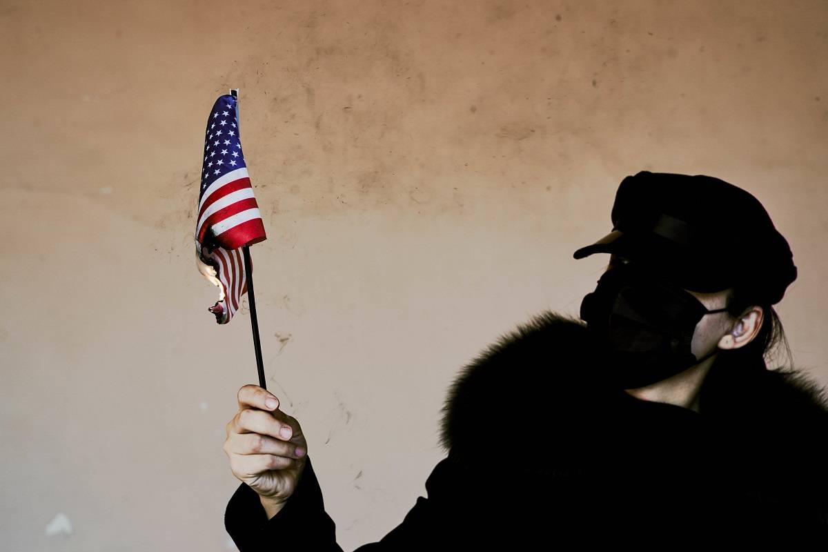 Жена гори американско знаме в знак на протест, 8 януари 2021 г. Снимка: Marco Verch, Flickr