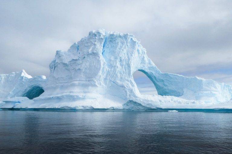 Тунел в айсберг, заснет до Портал Пойнт (антарктически полуостров). Този айсберг е с височина около четири етажа. Снимка: Derek Oyen, Unsplash