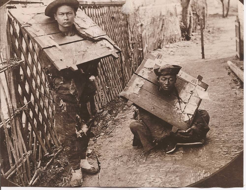 Мъж и жена, наказани да носят кангал в Хонконг в края на XIX век. Източник: China Postcard