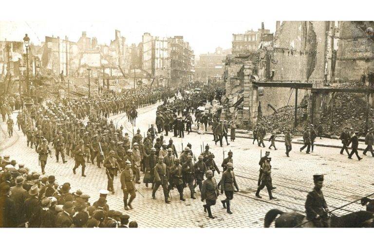 Огромна процесия от германски войници влиза в град, разрушен от бомбардировките. Местоположението на града е неизвестно.