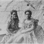 Портрет на две жени от Самоа, облечени в традиционно облекло. Едната от жените държи цигара в устата си. Снимката е направена около 1910 г. от неидентифициран фотограф. Източник: National Library of New Zealand