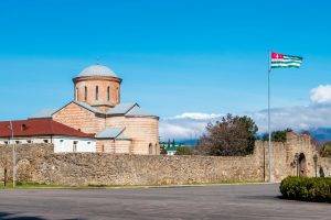Знамето на Абхазия се вее до църква. Снимка: Андрей Метелев, Unsplash