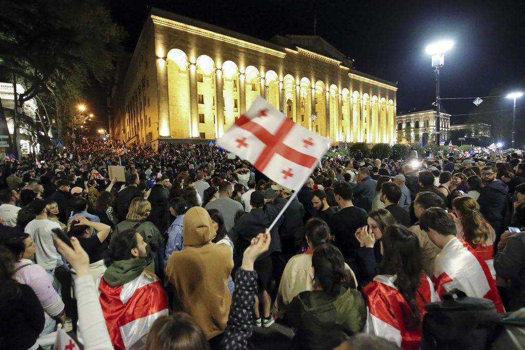 Демонстранти развяват грузинското национално знаме, докато се събират пред сградата на парламента в Тбилиси, Грузия, април 2018 г. Снимка: AP / Zurab Tsertsvadze